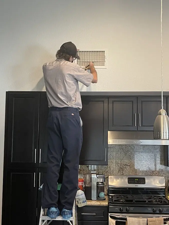 Technician inspecting an air vent during HVAC service in Shaker Heights